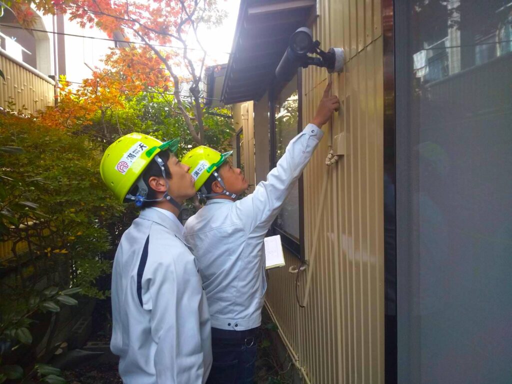 写真：建物の調査方法を先輩社員が部下へ指導している