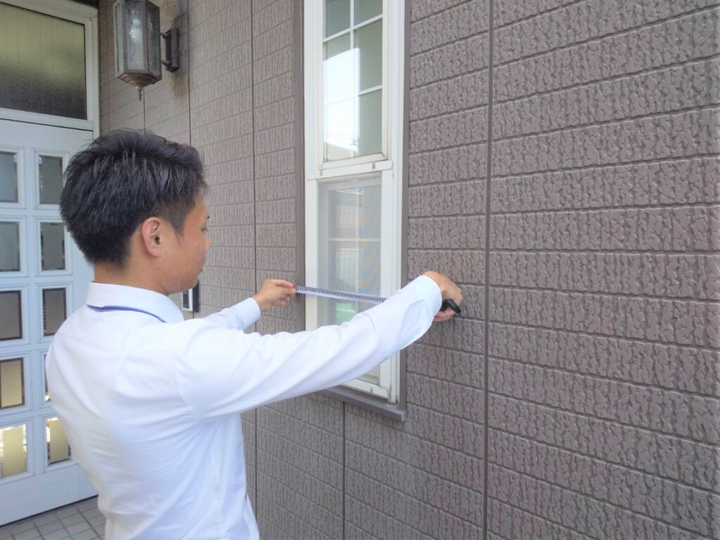 写真：窓の寸法を測る人