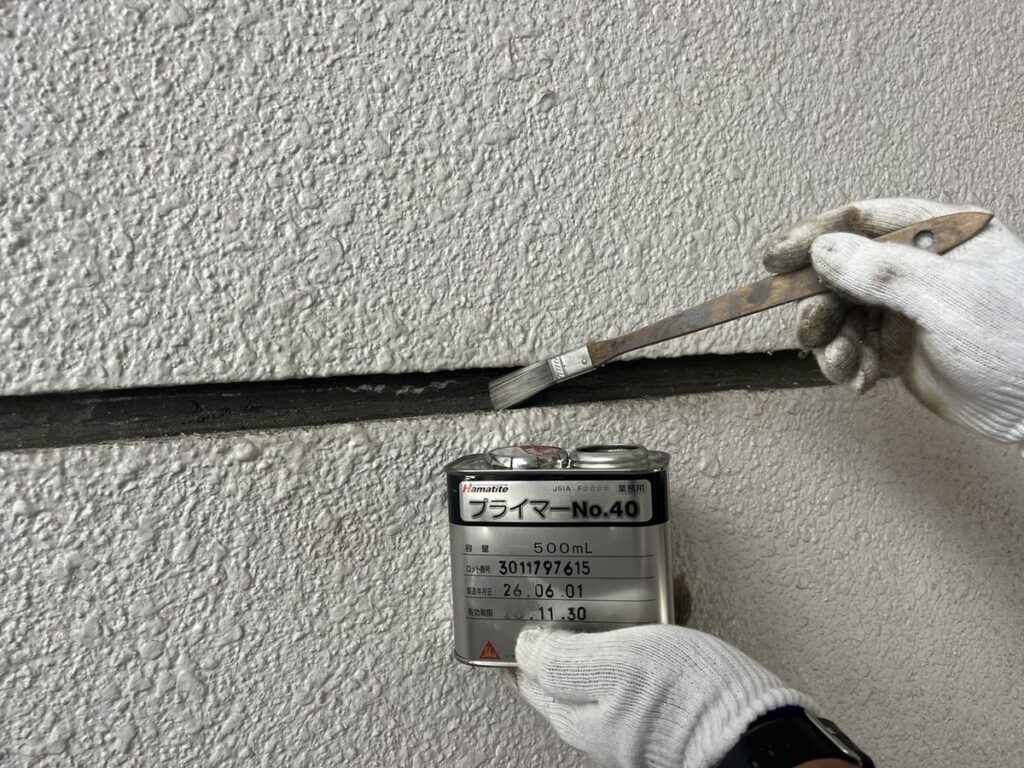 外壁目地にシーリング用プライマーを塗布している様子